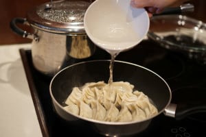 how to make gyoza - adding water to pan
